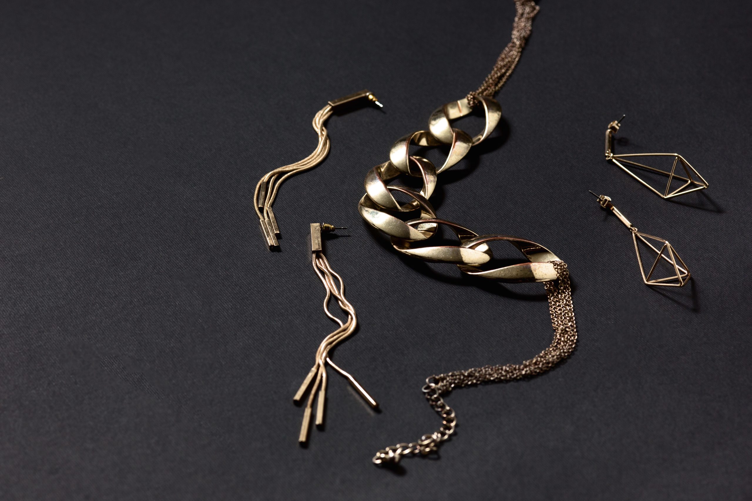 Gold jewelry arranged on a dark textile