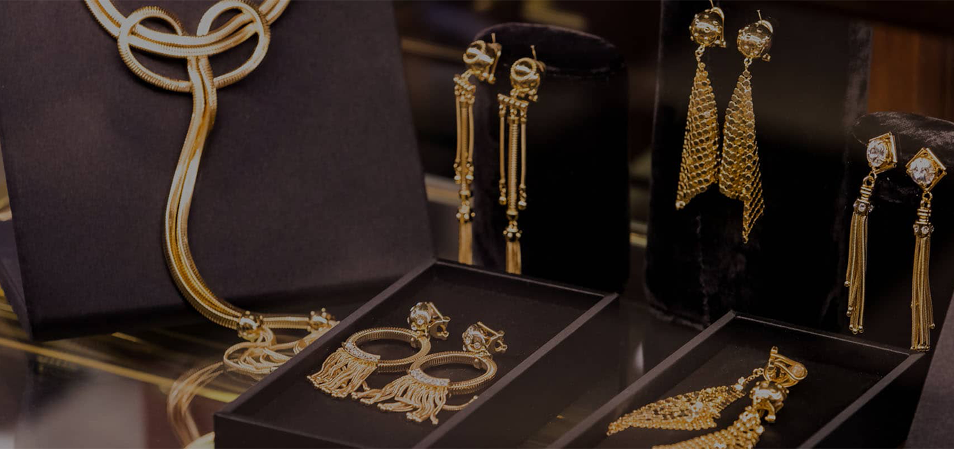 Gold jewelry arranged on black display trays