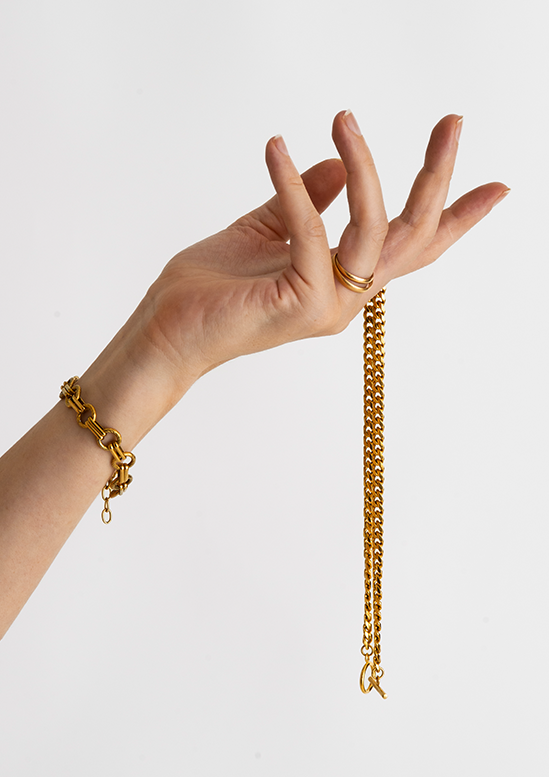 A hand holding a gold chain